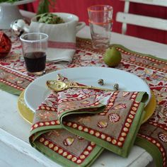 the table is set with place mats and napkins on it, including an apple