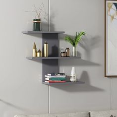 three white shelves with plants and vases on them against a wall in a living room