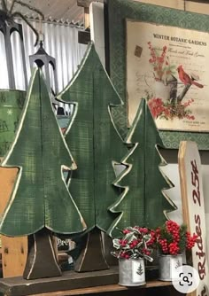 christmas trees are displayed on a shelf in a shop with other holiday items and decorations