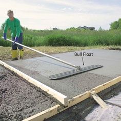 a man is pouring concrete with a mop