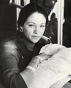 a black and white photo of a woman holding a baby