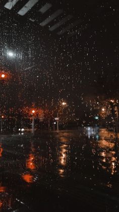 rain is falling down on the street at night