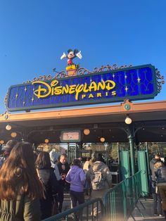 the entrance to disneyland park with people standing outside