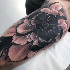 a black and white flower tattoo on the arm