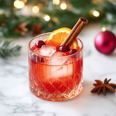 a drink with orange slices, cinnamon and anisette garnish on the rim