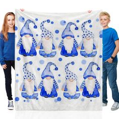 a boy and girl holding up a blue and white towel with gnomes on it