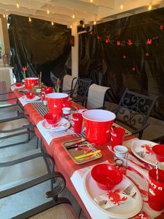 a long table with red cups and plates on it