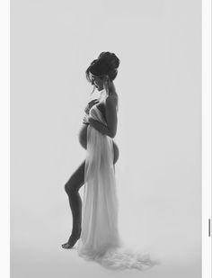 a pregnant woman is posing for a black and white photo