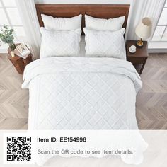 a bed with white comforter and pillows in a room