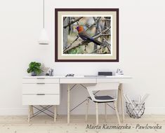 a bird sitting on top of a tree branch next to a white desk