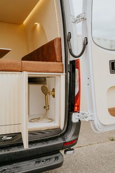 the back end of a white van with its door open and an outlet in it