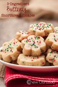 a plate full of sugar cookies with sprinkles on it and a red napkin