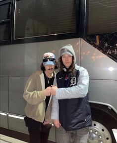 two people standing in front of a bus