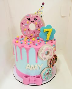 a birthday cake decorated with donuts, doughnuts and sprinkles