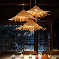 a wooden table topped with plates and cups under chandelier hanging from the ceiling