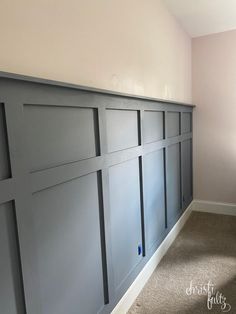 an empty room with gray paneling on the walls