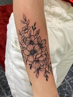 a black and white flower tattoo on the arm