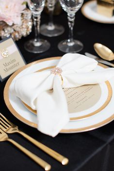 a black table with white and gold place settings