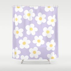 a purple shower curtain with white and yellow daisies on the outside, in front of a gray background