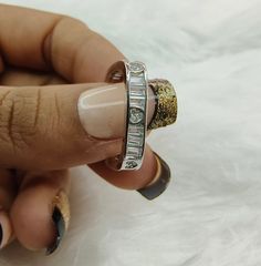 a woman's hand holding onto a ring with diamonds on the inside and outside