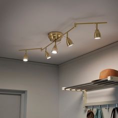 three lights are hanging from the ceiling in a room with white walls and open closet doors