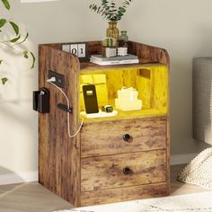 a small wooden cabinet with some items on it and a plant in the corner next to it