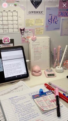 a laptop computer sitting on top of a desk next to a pile of writing paper