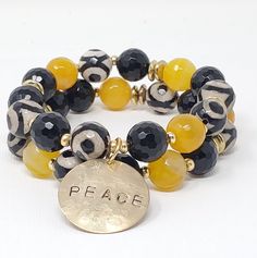 Black, White & Yellow Gemstone Bracelet Affirmations are an important part of living the life you want. Sometimes, you may need a reminder throughout the day. The bracelets are a perfect addition to the Affirmation Gear that add a pop of color. You get to choose your word: PEACE (shown), LOVE, DOPE, ENOUGH, FREE. 12mm Tibetan agate and yellow agate, with brass spacers and hand stamped recycled brass charm. Fits wrists approximately 6.5"-7.5". Every item sold plants a tree. Yellow Bracelet Ideas, Mens Stretch Bracelets, African Beaded Bracelets, Vintage Jewelry Ideas, Yellow Agate, Living The Life, Yellow Gemstones, Bracelet Display, Black White Yellow