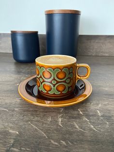 a coffee cup and saucer sitting on top of a wooden table