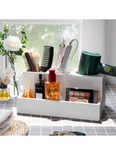 a bathroom shelf with various items in it and flowers on the window sill behind it