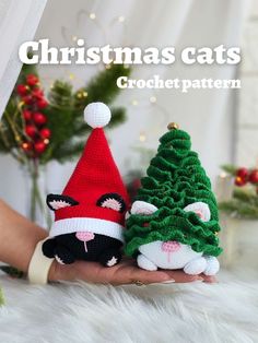 two crocheted christmas cats sitting next to each other in front of a tree