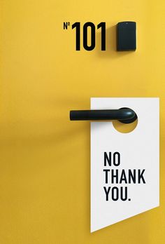 a sign that says no thank you hanging on a yellow wall next to a black and white marker