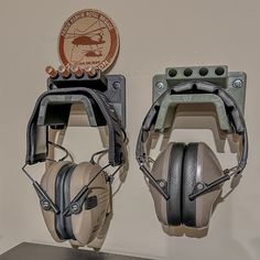 two headsets mounted to the wall with ear muffs on each one and a plaque above them