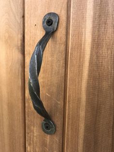 a door handle on the side of a wooden door that has been made to look like a vine