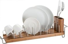 a wooden tray holding white dishes and silverware