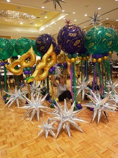 a woman sitting on the floor in front of some christmas decorations and star shaped balloons