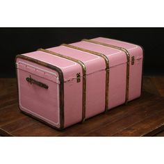 three pink suitcases sitting on top of a wooden table