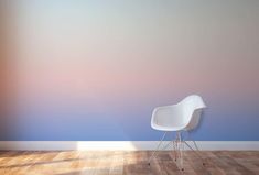 a white chair sitting on top of a hard wood floor next to a blue wall