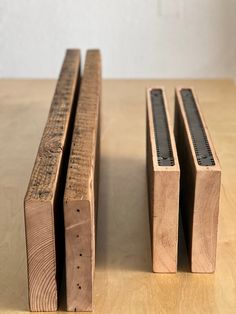 two pieces of wood sitting on top of a wooden table next to another piece of wood