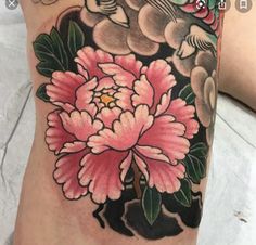 a close up of a person's leg with a flower tattoo design on it