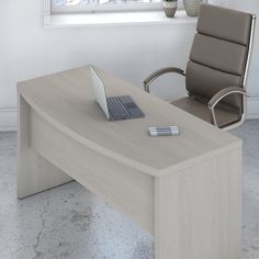 an office desk with a laptop on it and a chair next to it in front of a window