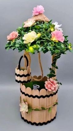 a wooden basket filled with flowers on top of a gray background and an umbrella shaped planter