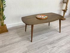 a wooden table with a plate of food on it in front of a bamboo plant