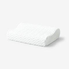 a white pillow on top of a white surface with the cover pulled down to reveal a chevron pattern