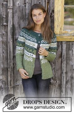 a woman standing in front of a wooden wall wearing a green and white cardigan