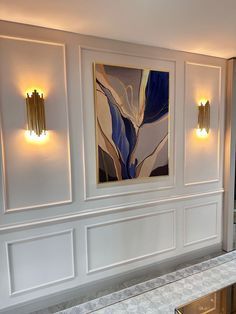 an elegant bathroom with white walls and gold trim around the bathtub, artwork on the wall