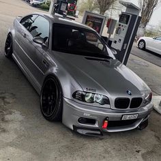 a silver car parked next to a gas pump