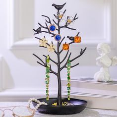 there is a tree that has beads on it and birds sitting on the branches next to it