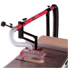 a table sawing machine with a red handle on it's end and a white hose attached to the blade