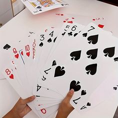 a person holding six playing cards on top of a table